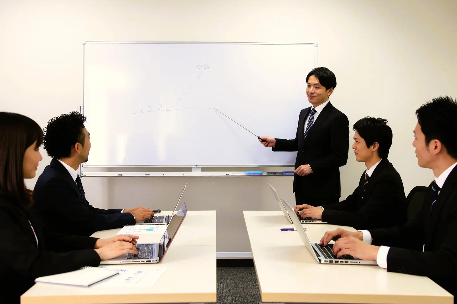 現場に常駐するエンジニアが、社員に向けてAI活用の進め方を説明している様子